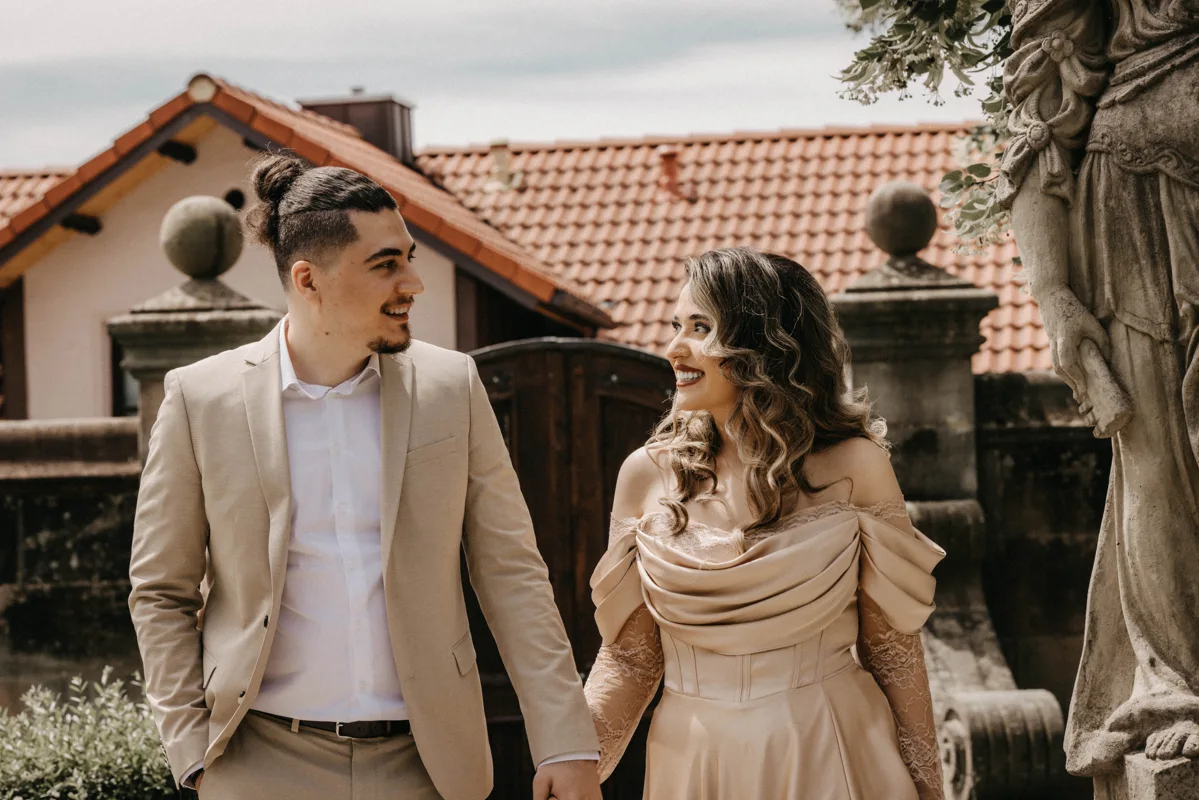 Ein Paar lächelt sich in einem historischen Innenhof an