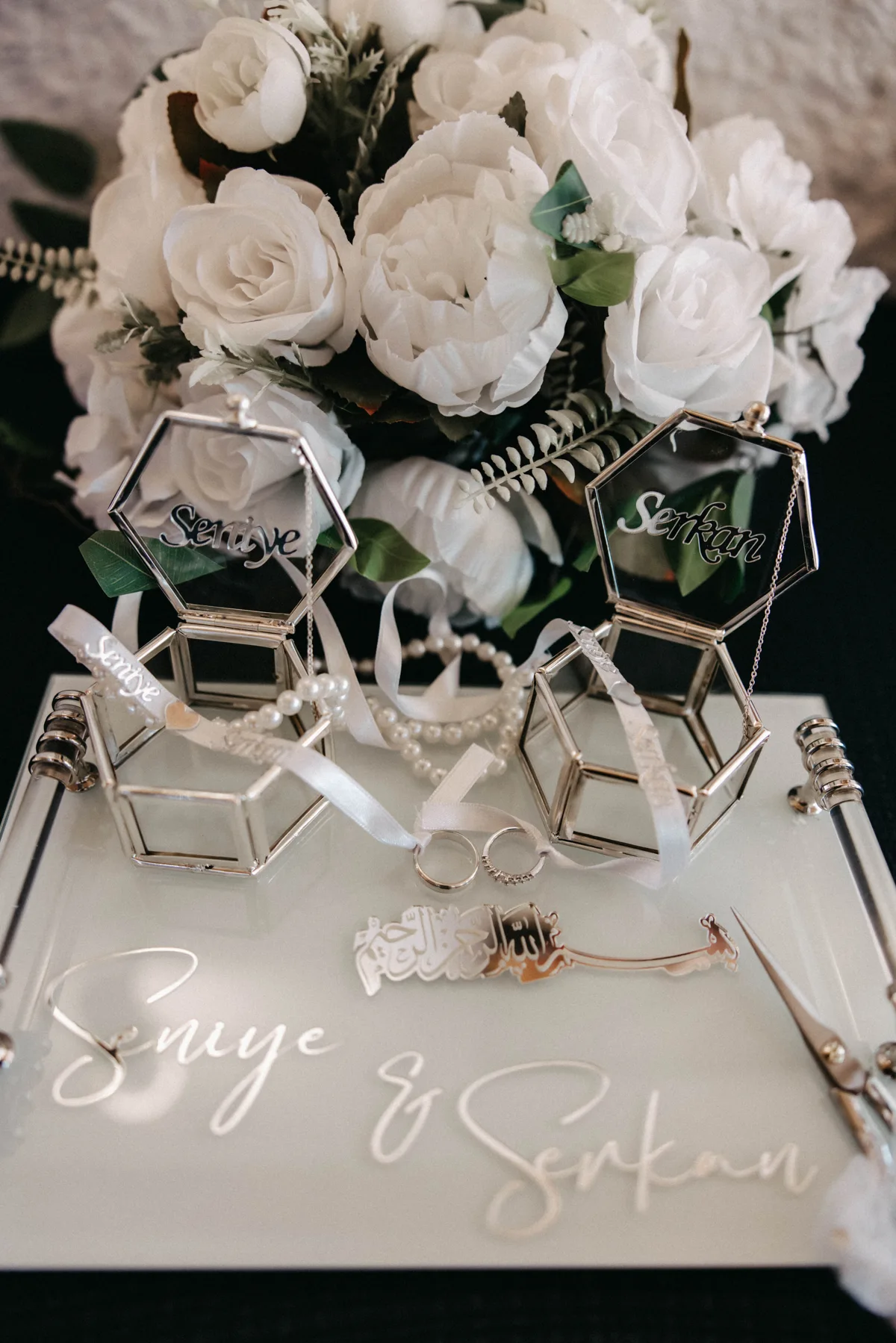 Weiße Rosen und Ringe auf einem Verlobungstablett