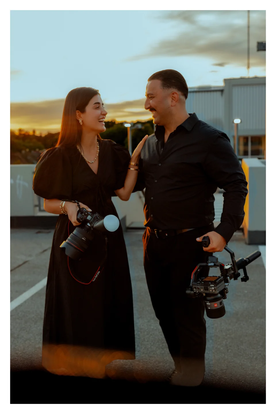 Sevtu und Tarik, das Künstler-Duo hinter Lens Media 25, lachend mit Foto- und Filmkamera